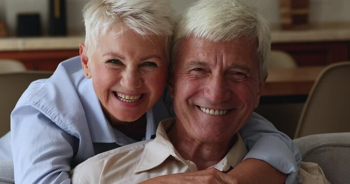 Close up portrait joyful wife cuddles husband family smile look at camera. Eternal love, romantic relations and understanding between mature spouses. Medical insurance cover for older citizen concept