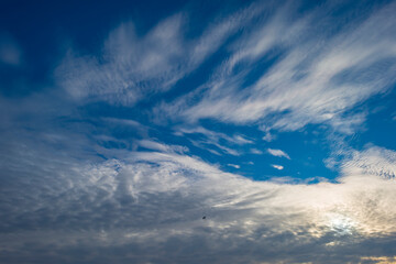 Naklejka na ściany i meble Dark white clouds in a blue sky in bright sunlight in winter, Almere, Flevoland, The Netherlands, January, 2021