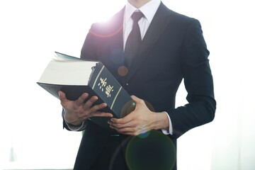 Lawyer holding law book.Chinese character 'beobjeon' means code of laws,law book.