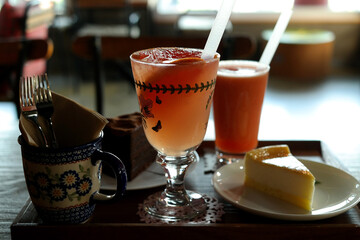 Grapefruit drinks and cakes are provided on the tray.