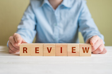  The word REVIEW on wooden cube block on wood table