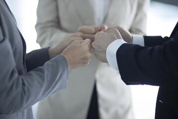 Fototapeta premium Business people holding fists in round circle in office