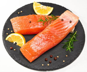 Red fish. Raw salmon fillet with rosemary, peppercorns and lemon isolate on white background. Clipping path and full depth of field. Top view
