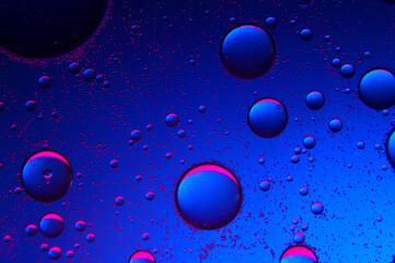 abstract background. drops of oil on water, blue and red. macro