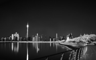 A grayscale shot of buildings in Dubai in night lighting.