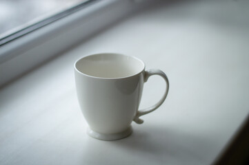 White tea cup isolated on white windowsill