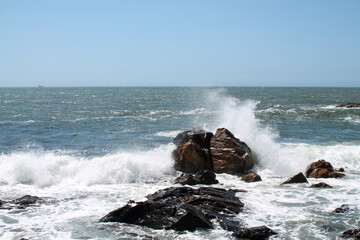 wave crashes against rock in the sea