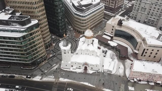 Drone slowly flies over the temple on Tverskaya Zastava overlooking skyscrapers and road traffic