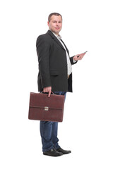Full body young businessman holding a briefcase and using mobile phone