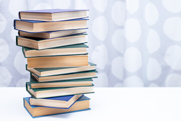 A stack of books on a white table and space for copying.