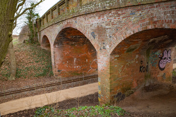 Fototapeta na wymiar Bridge constructed from red brick over the Bure Valley Railway line in the Norfolk countryside