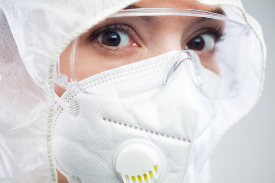 Closeup Headshot Of Terrified UK NHS Female Nurse Or Doctor Wearing Protective PPE Face Mask