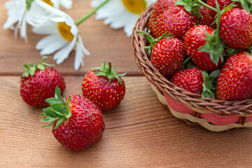 Ripe juicy strawberries on a wooden table. Healthy food rich in fiber, vitamins, antioxidants. Vegetarian food.