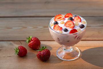 Yogurt with summer berries on a wooden table. Healthy food rich in fiber, vitamins and antioxidants.