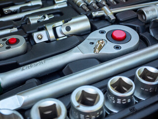 A close-up of a set of tools for repairing a car and other things. wrenches, bits, attachments. Side view, Selective focus