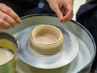 A close-up of a craftsman making an object out of clay on a potter's wheel. Handmade, hobby, hobby, selective focus