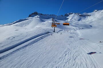 Ski lift in a ski resort in the german alps. Skiers on a ski slope on a sunny winter day.