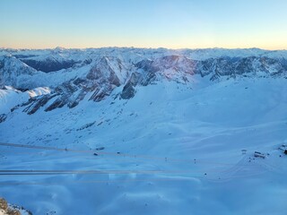 Panorama of ski resort in the german alps. Skiers on a slope on a sunny winter day.