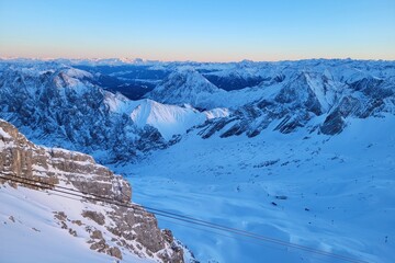 Panorama of ski resort in the german alps. Skiers on a slope on a sunny winter day.