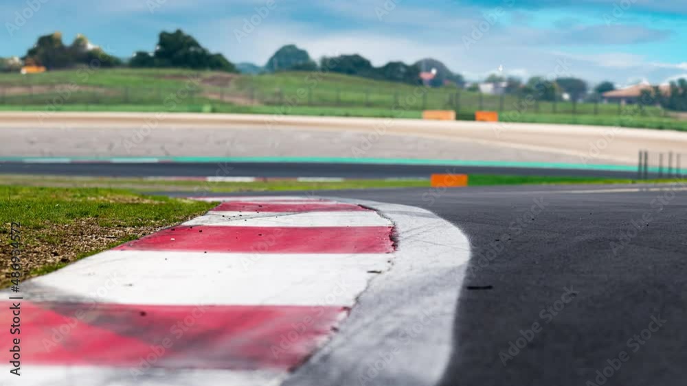 Wall mural Motor sport race track view curb detail selective focus curve low angle view, time lapse animation, competition concept