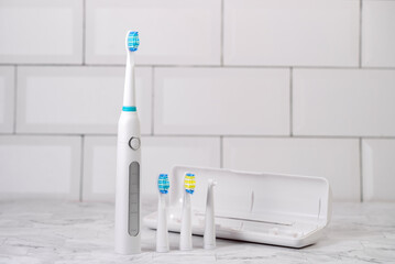 Modern white sonic or electric toothbrush with replacement heads. Concept of professional oral care and healthy teeth by using sonic smart toothbrush. Minimal design