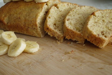 Chleb bananowy na drewnianej desce z plastrami banana obok