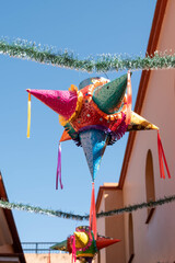 Colorful pinata made of metal, with a blue sky background at a mall in Oaxaca, Mexico