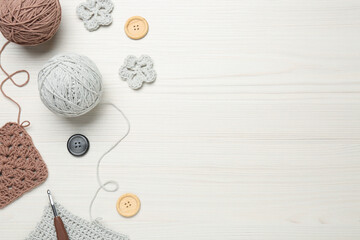 Flat lay composition with knitting threads and crochet hook on white wooden table, space for text - obrazy, fototapety, plakaty