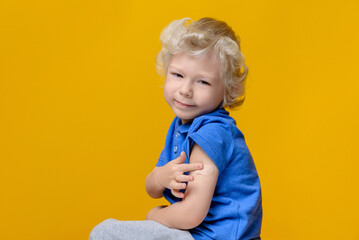 Child vaccination concept. A child with a patch on his shoulder after being vaccinated against coronavirus covid-19.
