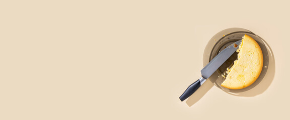 Pie on a plate, a knife on a beige background. Top view, flat lay. Banner.