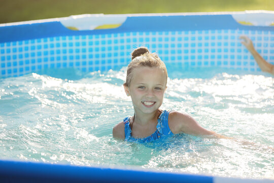 Portrait smiling girl in swimming pool, child playing. Summer vacation or classes. Summertime and swimming activities for happy children on the pool