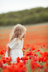 Pretty little girl on a poppy field, outdoor
