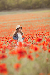 Pretty little girl on a poppy field, outdoor