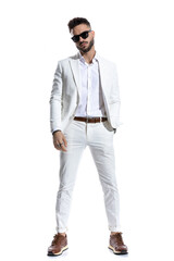 Naklejka premium bearded businessman with eyeglasses holding hand in pocket and posing