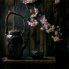 Tea drinking ceramic cup and teapot with blooming cherry branches