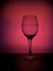 Pink bubbly, glass of wine with bubbles outside.