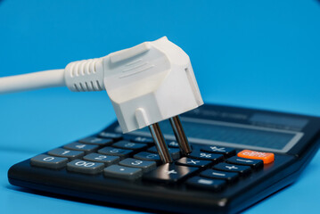 Electricity growth concept. Calculator and AC power plug.