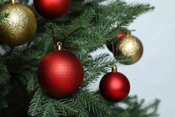 Beautiful Christmas tree with shiny baubles on white background, closeup
