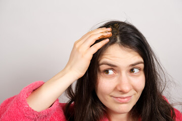 A brunette woman applies a natural Ayurvedic blend of herbs to her hair, scalp mask and scrub, hair care at home.