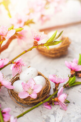 Spring blossom, Easter concept, miniature bunny, flowering tree close-up and copy space. Pink natural texture of natural flowering tree. Easter egg and branches of blossoming on an table..