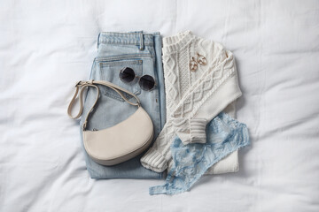 Fall fashion. Layout with woman's outfit on white bed, top view