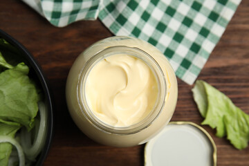 Jar of delicious mayonnaise and fresh salad on wooden table, flat lay