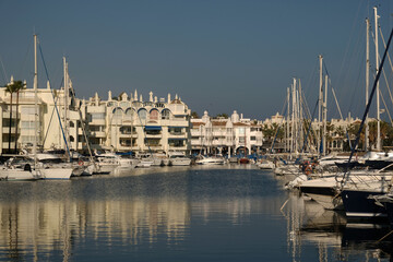 Boats in a yacht club in the Mediterranean sea, Malaga, Spain. Yachts moored in the port on sunny day, Reflection in water.