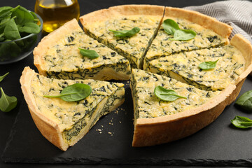 Cut delicious spinach pie on slate plate, closeup