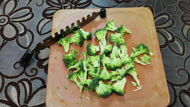 Broccoli finely chopped on aplastic vegetable cutter for stir fry