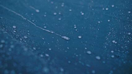Close-up shot of raindrops water droplets on the tent. Dew drops on texture of fabric of tourist tent in rays of rising or setting sun. Camp, hiking tourism. The rain is pounding on tent.