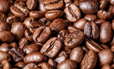 Fototapeta premium Freshly roasted coffee beans background.Dark roasted coffee beans with scoop on wooden background.