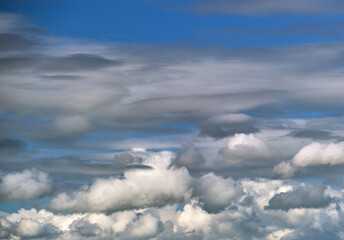Bright landscape of white puffy cumulus clouds on blue clear sky