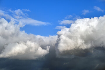 Bright landscape of white puffy cumulus clouds on blue clear sky