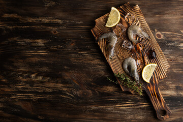 Raw shrimps with lemon slices and ice cubes, frozen prawns.